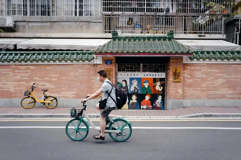 Chinese man riding an electric bike on a paved road